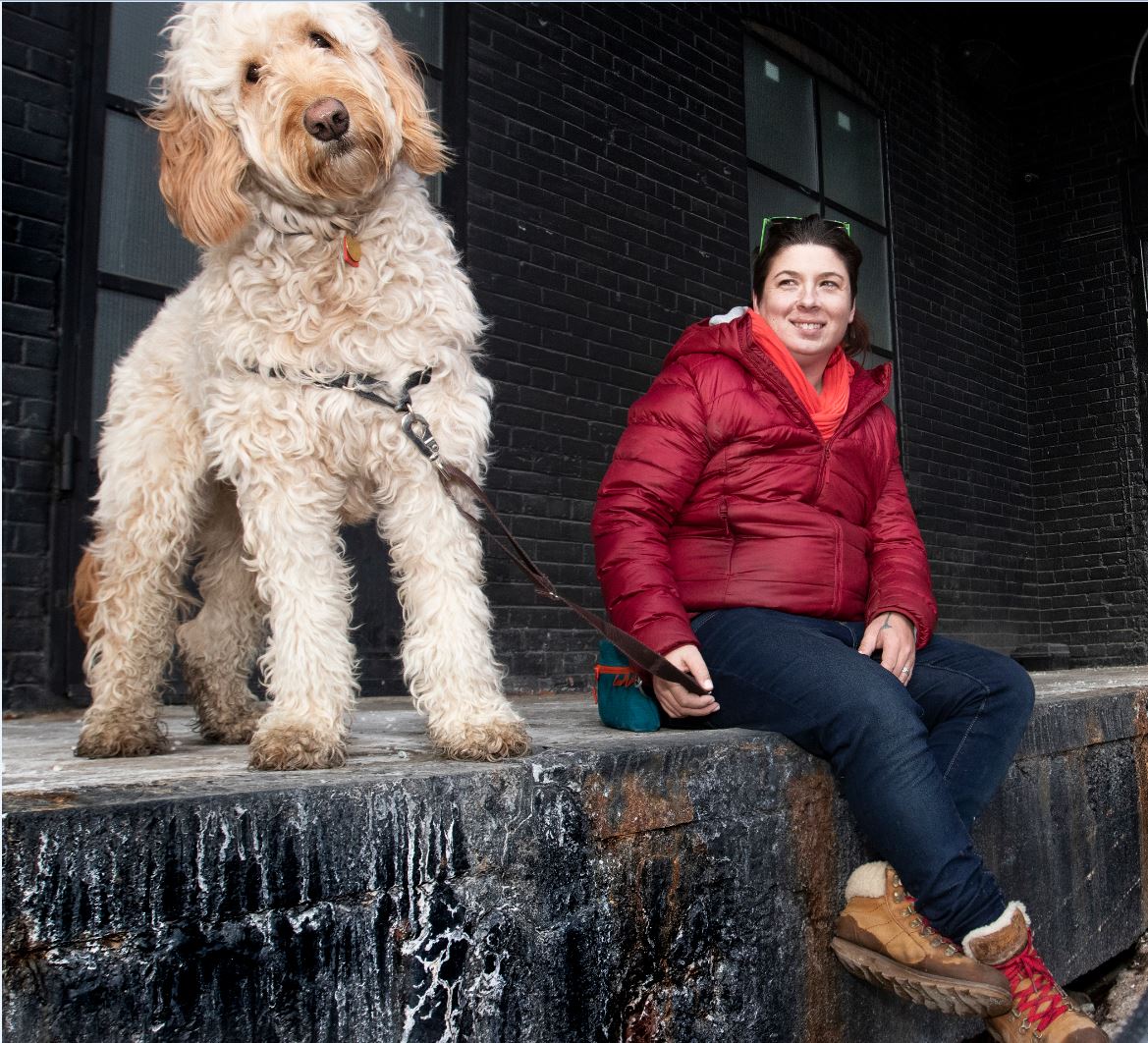 Erin sitting beside a large doodle